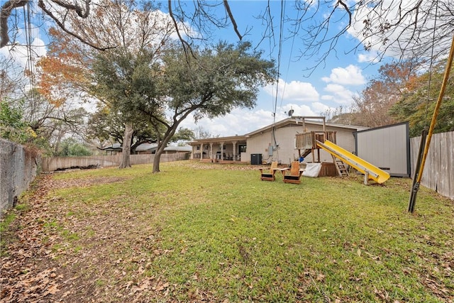 view of yard featuring a playground and central air condition unit