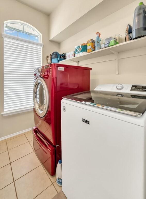 clothes washing area with washer and dryer and light tile patterned flooring