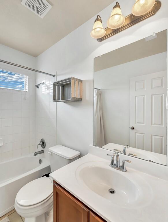 full bathroom featuring shower / bath combo, vanity, toilet, and tile patterned floors