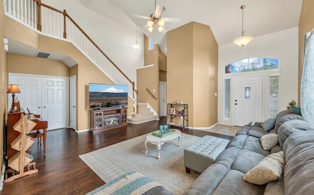 living room with ceiling fan, dark wood-type flooring, and high vaulted ceiling