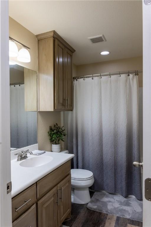 bathroom with hardwood / wood-style floors, vanity, and toilet