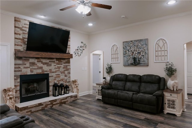 living room with a fireplace, dark hardwood / wood-style flooring, ceiling fan, and ornamental molding