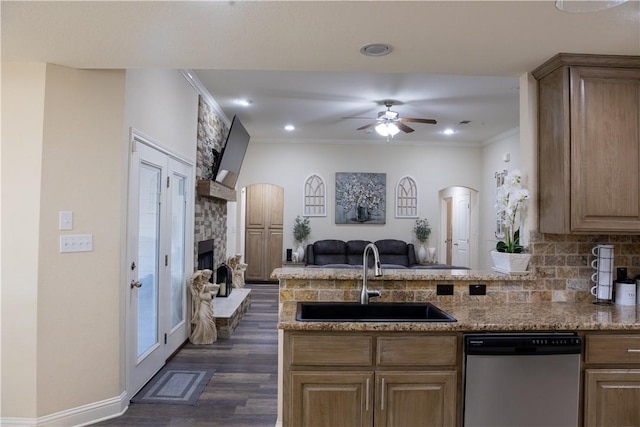 kitchen with a stone fireplace, crown molding, sink, stainless steel dishwasher, and dark hardwood / wood-style flooring