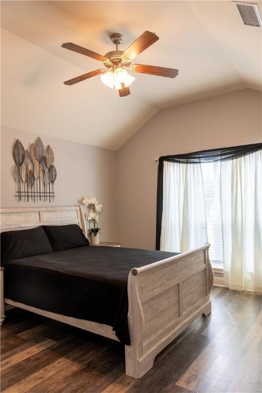 bedroom with ceiling fan, dark hardwood / wood-style flooring, and lofted ceiling