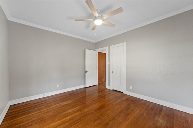 empty room featuring crown molding, dark wood-type flooring, and ceiling fan