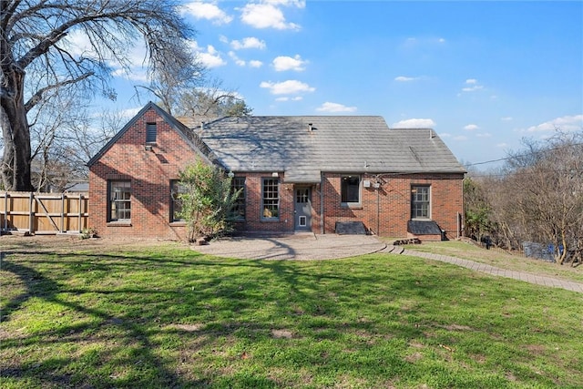 back of house featuring a lawn and a patio