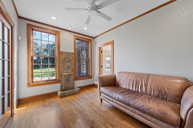 living room featuring ornamental molding, ceiling fan, and light hardwood / wood-style flooring