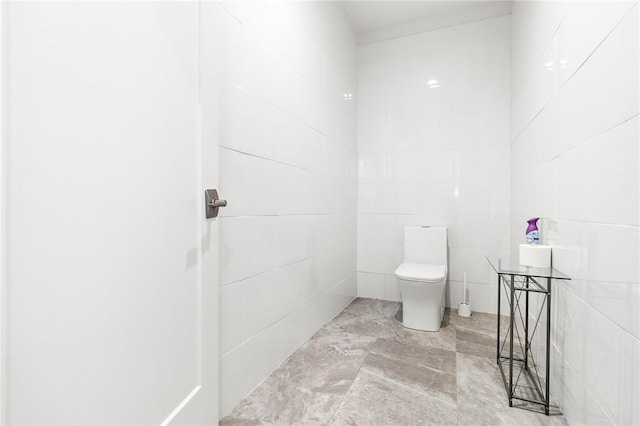 bathroom with tile walls and toilet