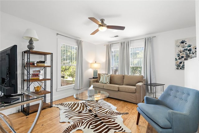 living room with light hardwood / wood-style flooring, plenty of natural light, and ceiling fan