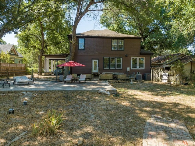 back of property with a lawn, a patio, and central AC