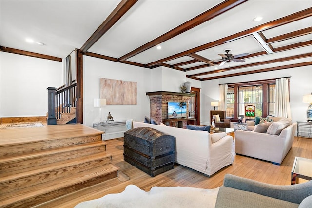 living room featuring beamed ceiling, ceiling fan, and light wood-type flooring