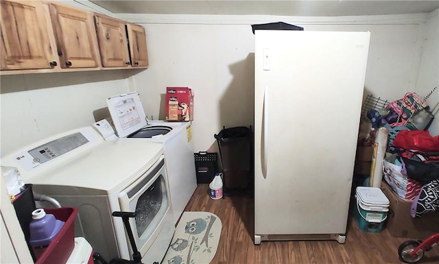 clothes washing area with cabinets, washer and dryer, and dark hardwood / wood-style flooring