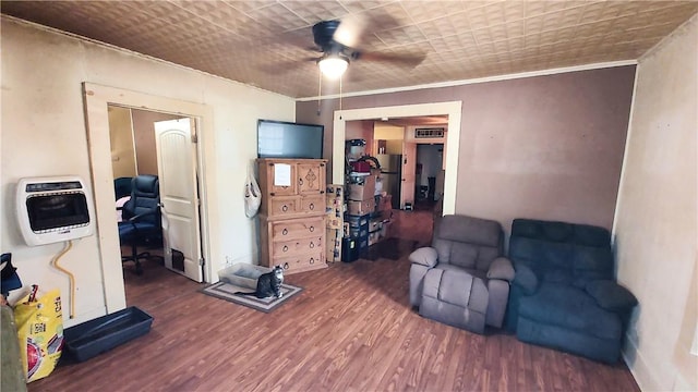 sitting room with dark hardwood / wood-style floors, ceiling fan, crown molding, and heating unit