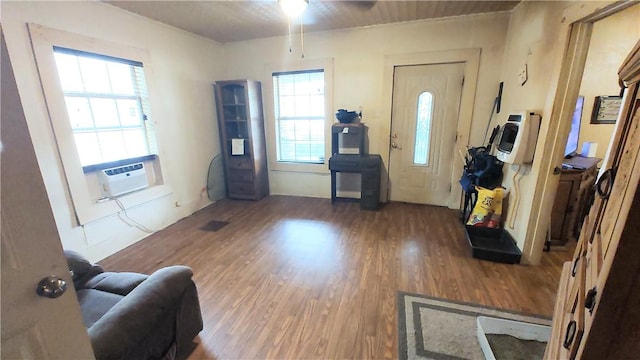 foyer entrance with dark hardwood / wood-style flooring, a wealth of natural light, cooling unit, and ceiling fan