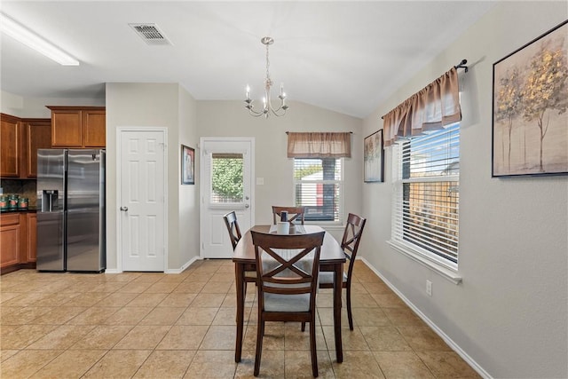 dining room with light tile patterned floors, vaulted ceiling, an inviting chandelier, and a wealth of natural light