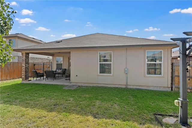 rear view of property with an outdoor living space, a patio area, and a lawn