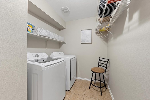 clothes washing area featuring washer and dryer and light tile patterned floors