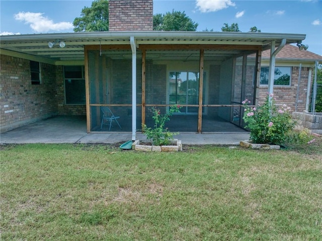 back of house with a yard, a patio area, and a sunroom