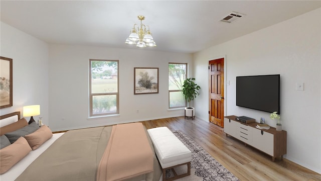 bedroom featuring an inviting chandelier and light hardwood / wood-style floors