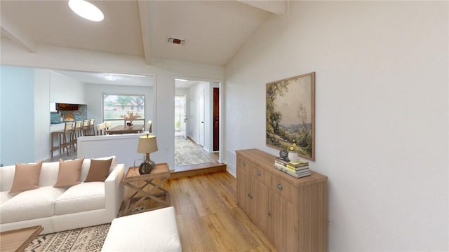 living room with lofted ceiling with beams and light hardwood / wood-style floors