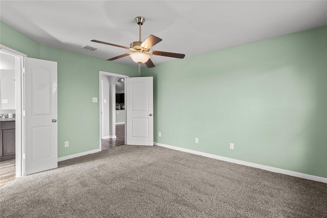 unfurnished bedroom with connected bathroom, ceiling fan, and carpet flooring