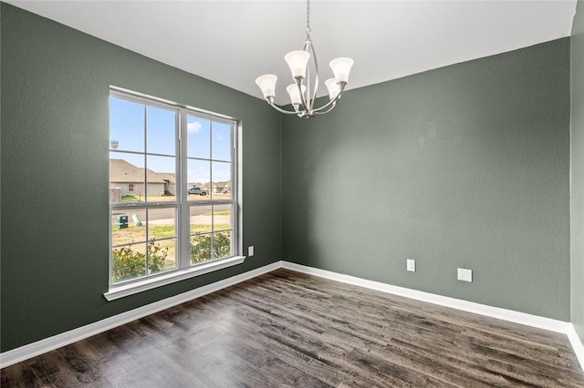 unfurnished room with an inviting chandelier and dark wood-type flooring