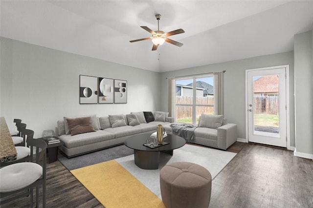 living room with ceiling fan, dark hardwood / wood-style flooring, and vaulted ceiling