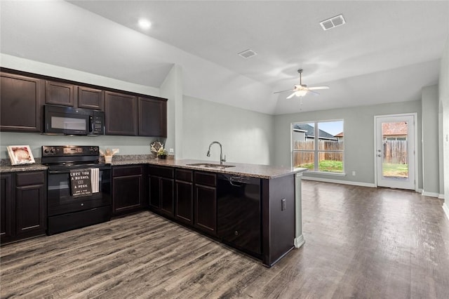 kitchen featuring dark brown cabinetry, sink, kitchen peninsula, hardwood / wood-style floors, and black appliances