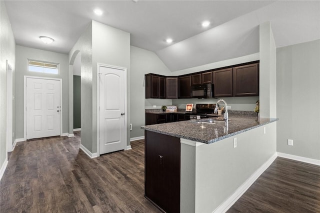 kitchen with sink, dark hardwood / wood-style flooring, kitchen peninsula, dark stone counters, and black appliances