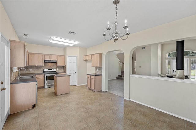 kitchen featuring light brown cabinets, a kitchen island, a notable chandelier, and electric stove