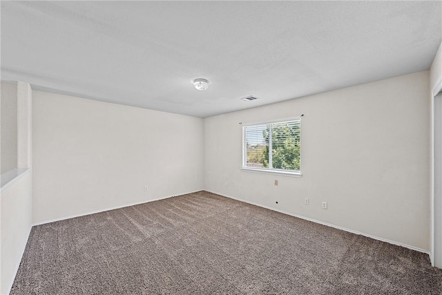 carpeted spare room featuring a textured ceiling