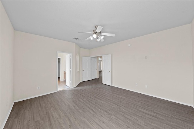 empty room featuring ceiling fan and dark wood-type flooring