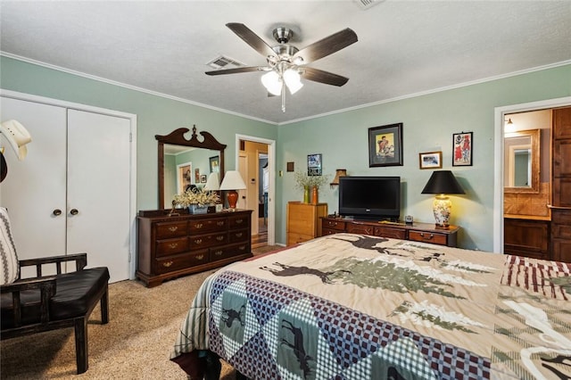 carpeted bedroom with ceiling fan, connected bathroom, a closet, a textured ceiling, and crown molding