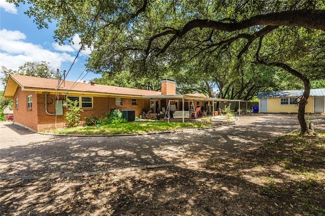 view of front of property featuring central AC unit and an outdoor structure