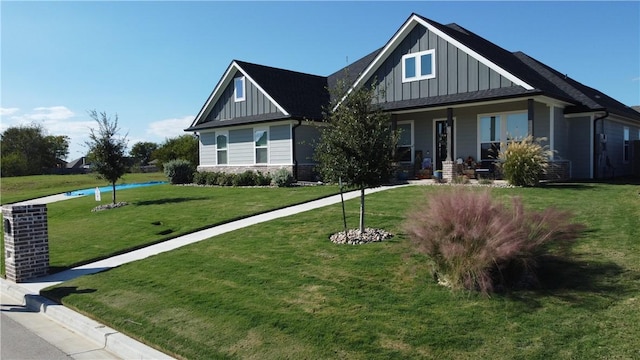 craftsman-style home featuring board and batten siding, a front yard, stone siding, and a porch