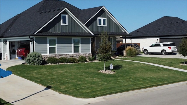 craftsman house featuring driveway, a garage, a front lawn, board and batten siding, and brick siding