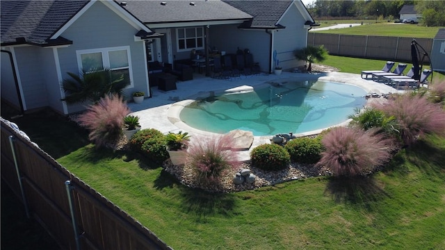 view of pool featuring a patio, a lawn, and a fenced backyard