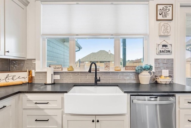 kitchen with tasteful backsplash, dark countertops, dishwasher, and a sink