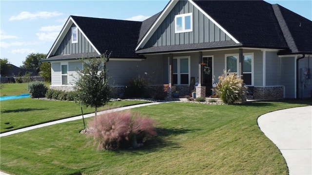 view of front of property with a front lawn, board and batten siding, and brick siding