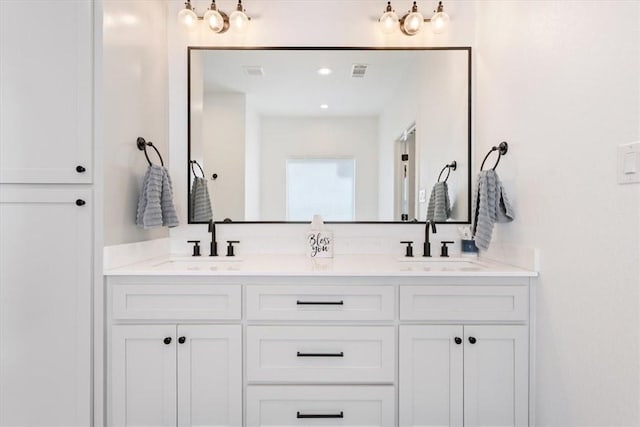 full bath with double vanity, visible vents, a sink, and recessed lighting