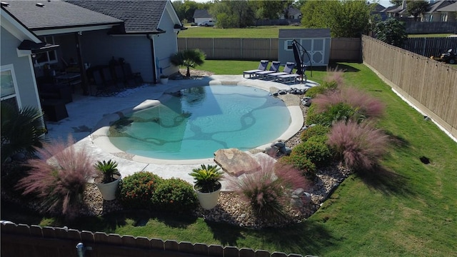 view of swimming pool with an outbuilding, a fenced backyard, a yard, a storage unit, and a patio area