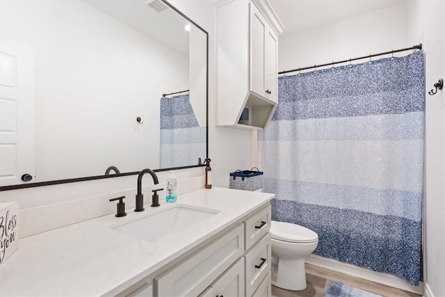 full bathroom featuring curtained shower, visible vents, toilet, vanity, and wood finished floors