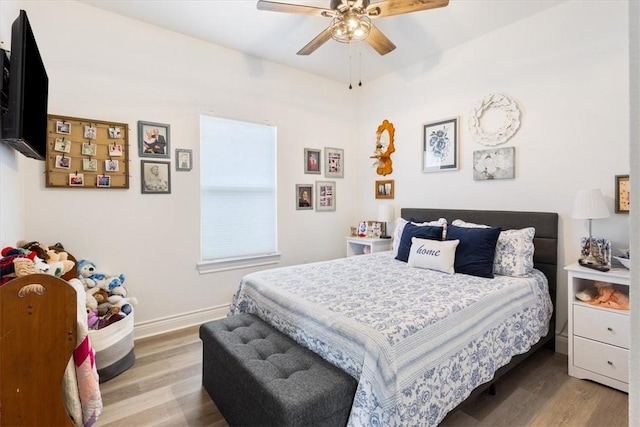 bedroom featuring a ceiling fan, baseboards, and wood finished floors