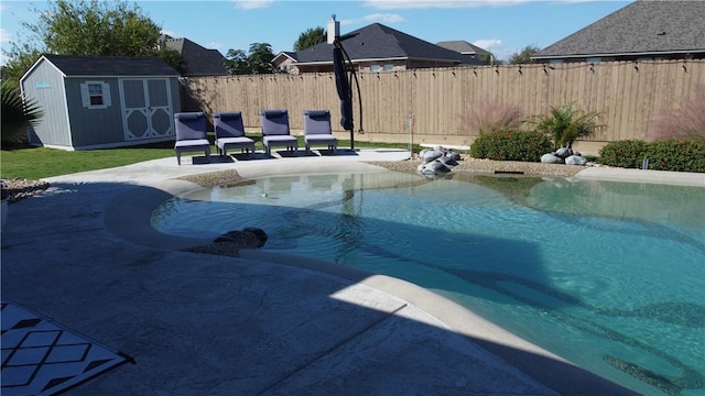 view of swimming pool with a patio, a fenced backyard, a storage shed, an outdoor structure, and a fenced in pool