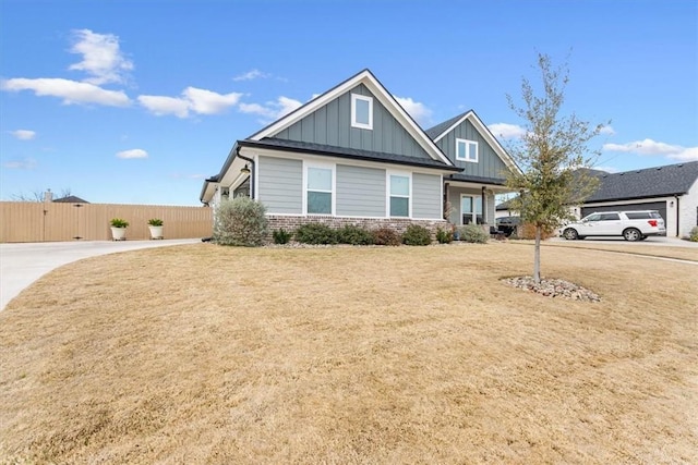 craftsman-style home featuring brick siding, board and batten siding, a front lawn, and fence