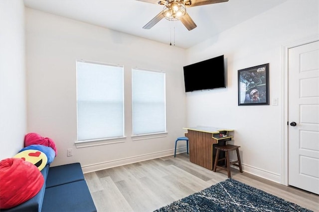 interior space with ceiling fan, wood finished floors, and baseboards