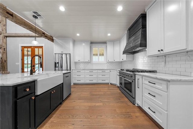 kitchen with stainless steel appliances, pendant lighting, and white cabinetry