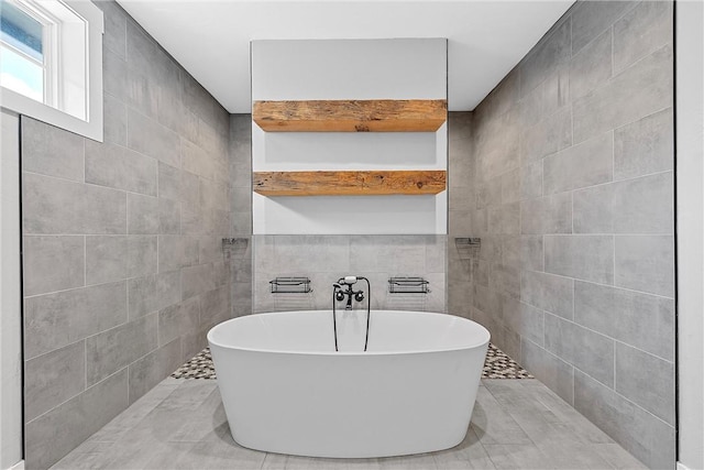 bathroom with tile walls and a tub to relax in