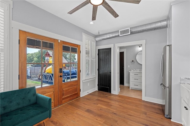 sitting room with ceiling fan, light hardwood / wood-style floors, and french doors