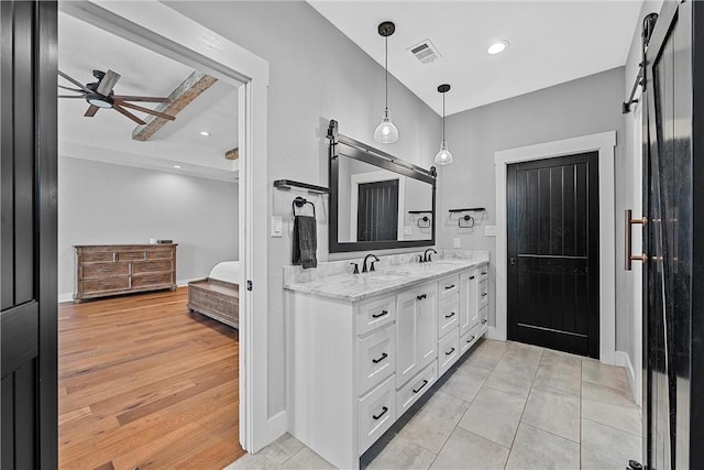 bathroom with ceiling fan, wood-type flooring, vanity, and beamed ceiling